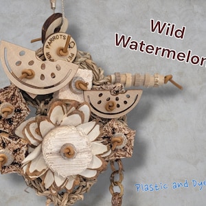 May include: A bird toy featuring wooden watermelon slices, textured bark pieces, and a central flower-shaped wood element, all strung together with natural fibres. The text Wild Watermelon and Plastic and Dye Free is visible on the image.