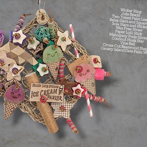 May include: A bird toy featuring a wicker ring base adorned with jute beads, two-toned palm leaf, balsa stars and squares, sola stars and sticks, wax-free straw, paper lolli sticks, mahogany pod slices, a coconut husk star, vine ball, and basswood.