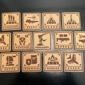 May include: Set of 12 brown cork coasters with various black and white illustrations. The coasters feature images of a spaceship, a building, a robot, a weapon, a person, and more. The coasters are rectangular and have a brown cork surface.
