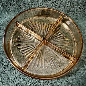 May include: A vintage amber glass divided serving dish with a sunburst pattern. The dish has four sections and is perfect for serving snacks or appetizers.