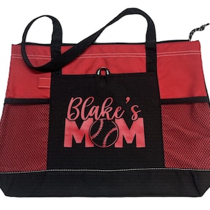 K&ouml;nnte beinhalten: Rote und schwarze Tragetasche mit einem Netzfach und einem gro&szlig;en schwarzen Fach mit dem Text "Blake's Mom" in Rot mit einer roten Baseballgrafik.