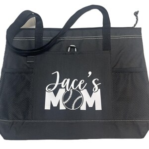 K&ouml;nnte beinhalten: Schwarze Tragetasche mit einem wei&szlig;en Baseball und dem Text "Jace's Mom" auf der Vorderseite.