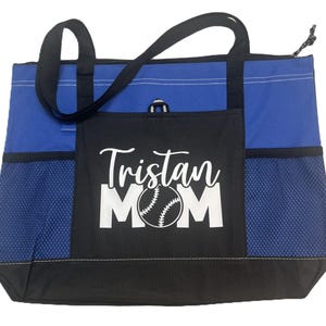 K&ouml;nnte beinhalten: Blaue und schwarze Tragetasche mit einem Netzfach und einem wei&szlig;en Design, das "Tristan Mom" mit einer Baseballgrafik sagt.