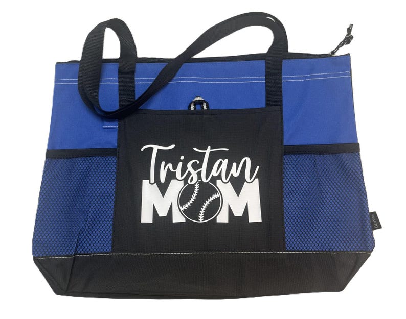 K&ouml;nnte beinhalten: Blaue und schwarze Tragetasche mit einem Netzfach und einem wei&szlig;en Design, das "Tristan Mom" mit einer Baseballgrafik sagt.