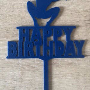 Puede incluir: Adorno azul para tarta con la silueta de un superh&eacute;roe y la inscripci&oacute;n "HAPPY BIRTHDAY". El adorno es de material s&oacute;lido y tiene un pin para insertar en una tarta.