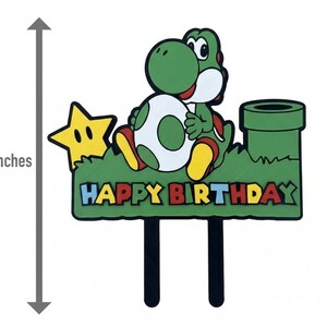 May include: A 15 cm tall birthday cake topper featuring Yoshi from the Super Mario Bros. series. Yoshi is green with a white and green egg, sitting on a green base with a yellow star and a green pipe. The words "HAPPY BIRTHDAY" are displayed.
