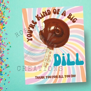 May include: A greeting card with a chocolate-covered lollipop design. The card features the text "YOU'RE KIND OF A BIG DILL" in a playful font, with the words "Thank you for all you do!" at the bottom. The background has a colorful swirl pattern.