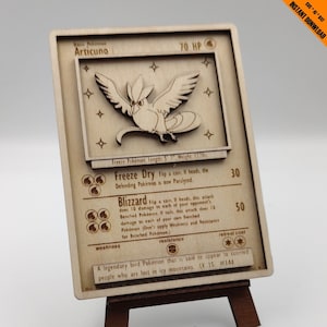 May include: A wooden Pokemon trading card featuring Articuno, a legendary bird Pokemon that is said to appear to people who are lost in icy mountains. The card has a brown background with white text and illustrations. The card is 70 HP and has a retreat cost of two stars. The card has two attacks: Freeze Dry and Blizzard.