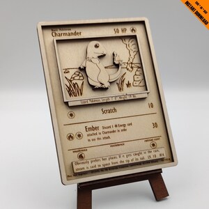 May include: A wooden Pokemon card featuring Charmander, a lizard Pokemon with a fiery tail. The card has a brown background and features the text "Basic Pokemon Charmander 50 HP". The card also includes the text "Lizard Pokemon. Length: 2' 0", Weight: 19 lbs."