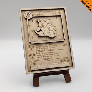 Puede incluir: Una carta de Pokemon de madera con Nidoking, un Pokemon marrón y beige con una puntuación de 90 PV. La carta tiene un fondo marrón con texto e ilustraciones blancas. El texto de la carta incluye el nombre del Pokemon, sus PV, sus ataques, su debilidad, su resistencia y su coste de retirada.