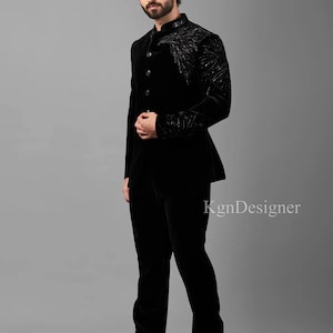 May include: A black velvet suit with a mandarin collar and a decorative design on the jacket. The suit is tailored and has a slim fit.