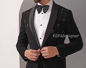 May include: A black tuxedo jacket with a satin lapel and a black bow tie. The jacket has a decorative pattern of black sequins on the lapel. The text "KGNDesigner" is visible on the jacket.