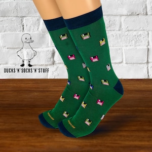 May include: A pair of green socks with a navy blue cuff. The socks feature a repeating pattern of colorful floppy disks.