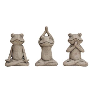 Könnte beinhalten: Drei steinfarbene Froschfiguren in Yoga-Posen. Ein Frosch hat die Hände im Schoß, ein anderer hat die Hände über dem Kopf und der dritte hat die Hände vor dem Gesicht zusammen. Alle sitzen.
