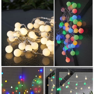 Könnte beinhalten: Ein Satz Lichterketten mit runden, weißen Glühbirnen. Die Lichter sind auf einem durchsichtigen Draht aufgereiht. Die Lichter werden in drei verschiedenen Umgebungen gezeigt, darunter ein Tisch, eine Wand und ein schwarzer Metallrahmen.