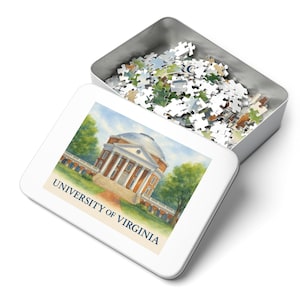 May include: A white puzzle tin with the University of Virginia logo. The tin is open, revealing a pile of puzzle pieces. The lid features a watercolor painting of a building with columns and the text "UNIVERSITY OF VIRGINIA".