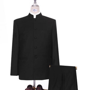 May include: A black suit with a mandarin collar jacket, matching trousers, and a pair of burgundy leather loafers with tassels. The suit is displayed on a mannequin, showcasing a formal attire ensemble.