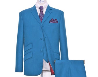 May include: A teal blue suit with a paisley patterned tie and pocket square. The suit includes a jacket, pants, and a vest. The suit is on a mannequin and the shoes are brown leather loafers with tassels.