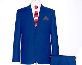 May include: A royal blue suit with a three-button jacket and matching pants. The jacket has a pocket square and the suit is displayed on a mannequin. The suit is paired with brown tassel loafers.