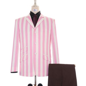 Puede incluir: Una chaqueta de rayas rosa y blancas con un pantalón marrón y un par de mocasines marrones con borlas.