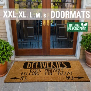 以下が含まれることがあります： 黒い文字で「Deliveries」と書かれた茶色のココナッツ繊維のドアマット。その下に「Does pineapple belong on pizza?」という文字が書かれており、矢印が「Yes」と「No」を指しています。ドアマットには「Natural Plastic Free」のラベルが付いています。