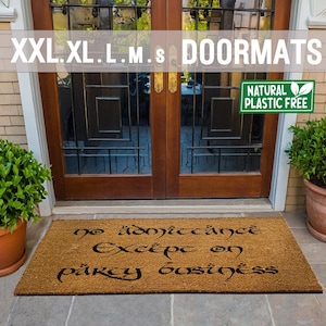 以下が含まれることがあります： 黒いスタイリッシュなフォントで「No admittance except on party business」と書かれた茶色のココナッツ繊維製のドアマット。ドアマットは、ガラスパネルが付いた二重の木製ドアの前にあります。ドアマットの右側には、テラコッタ製の鉢に入った緑色の植物があります。