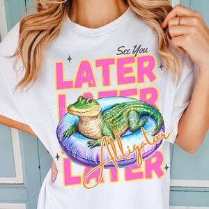 Funny “See You Later Alligator” t-shirt PNG design with cute hand drawn watercolor alligator lounging in a pool float, retro pink and yellow text, summer vacation vibes, beach day shirt, animal humor tee, playful wildlife graphic tee, tropical novelty shirt, kids or adult funny alligator shirt, swamp theme apparel, southern charm gifts, Florida summer shirts, best-selling lake trip shirts, popular quirky animal t-shirt design PNG.