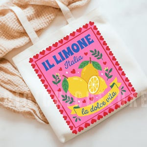 Pink Italian lemon shirt PNG design featuring bold yellow lemons, heart scalloped border, “Il Limone Italia” and “La Dolce Vita” text in retro Mediterranean style. Amalfi Coast aesthetic graphic tee design, lemoncore fashion, Italian summer shirt design, Italy vacation shirt, cute Europe travel apparel, feminine coastal citrus art, Italy lover gift, Lemon wall art, Mediterranean fruit illustration PNG clipart design.