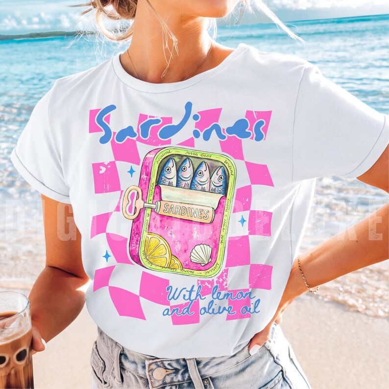 Trendy sardines shirt design featuring a pink illustrated sardine tin can with fish, lemon slices, shell detail, blue lettering, and hot pink checkerboard background. Cute Mediterranean foodie graphic perfect for coastal Europe vacations, European summer outfits design, fish market aesthetic, seafood lover gifts, retro vacation shirts design, beach trip apparel design, coastal boutique fashion, and trendy graphic shirt design for women, girls trips, and summer travel. For sublimation and DTF.