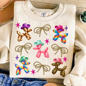 High-quality PNG design featuring cute Western balloon dogs wearing colorful cowboy hats in cow print, pink, tie-dye, and leopard patterns, surrounded by rope bows and retro stars; perfect for trendy coastal cowgirl T-shirts, rodeo shirts, Nashville bachelorette party outfits, girls trip apparel, country concert looks, western bachelorette decor, boho cowgirl gifts, summer rodeo outfits, and western fashion. 300 DPI transparent background for sublimation, DTF and DTG printing and craft projects.