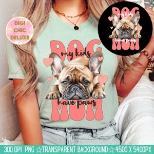 May include: A light green t-shirt with a pink and white graphic design featuring a French bulldog and the text "Dog Mom My Kids Have Paws".