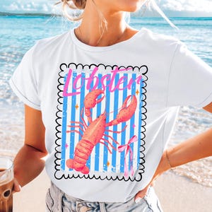 Bold watercolor lobster design with pink bow on nautical blue and white stripes — perfect for coastal cowgirl aesthetic, seafood lovers, Maine lobster festival gifts, retro summer beach vibes, ocean-themed apparel, and girly cottagecore fans. Trendy crustacean print for quirky fashion, East Coast preppy style, Y2K nautical chic, or seaside travel souvenir. Great for lobster parties, boating outfits, or colorful graphic tees with a fun foodie twist.
