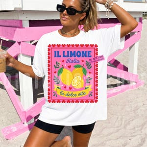 Pink Italian lemon shirt PNG design featuring bold yellow lemons, heart scalloped border, “Il Limone Italia” and “La Dolce Vita” text in retro Mediterranean style. Amalfi Coast aesthetic graphic tee design, lemoncore fashion, Italian summer shirt design, Italy vacation shirt, cute Europe travel apparel, feminine coastal citrus art, Italy lover gift, Lemon wall art, Mediterranean fruit illustration PNG clipart design.