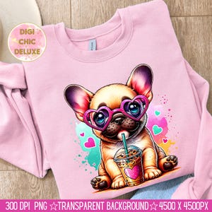 May include: A pink sweatshirt with a cartoon image of a French bulldog wearing heart-shaped sunglasses and holding a cup of iced coffee. The background is a watercolor design with pink hearts and blue and green splatters.