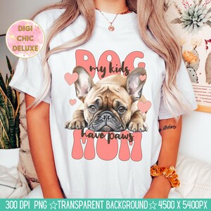 May include: A white t-shirt with a pink and brown illustration of a French bulldog. The text "Dog my kids have paws Mom" is written in pink letters.