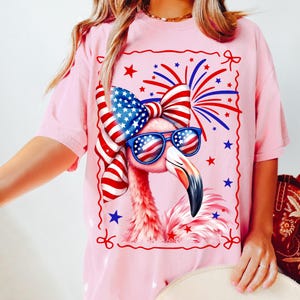 High quality hand drawn watercolor patriotic flamingo PNG design with USA flag coquette bow and American sunglasses, surrounded by red, white and blue fireworks. Perfect for 4th of July shirts, Independence Day outfit, beach party tee, funny summer graphic t-shirt tee, July Fourth flamingo lover gift, America-themed BBQ look, retro cute animal design, and trending patriotic women’s apparel. Great for lake days, family matching sets, coastal grandma style, and summer vacation fashion.
