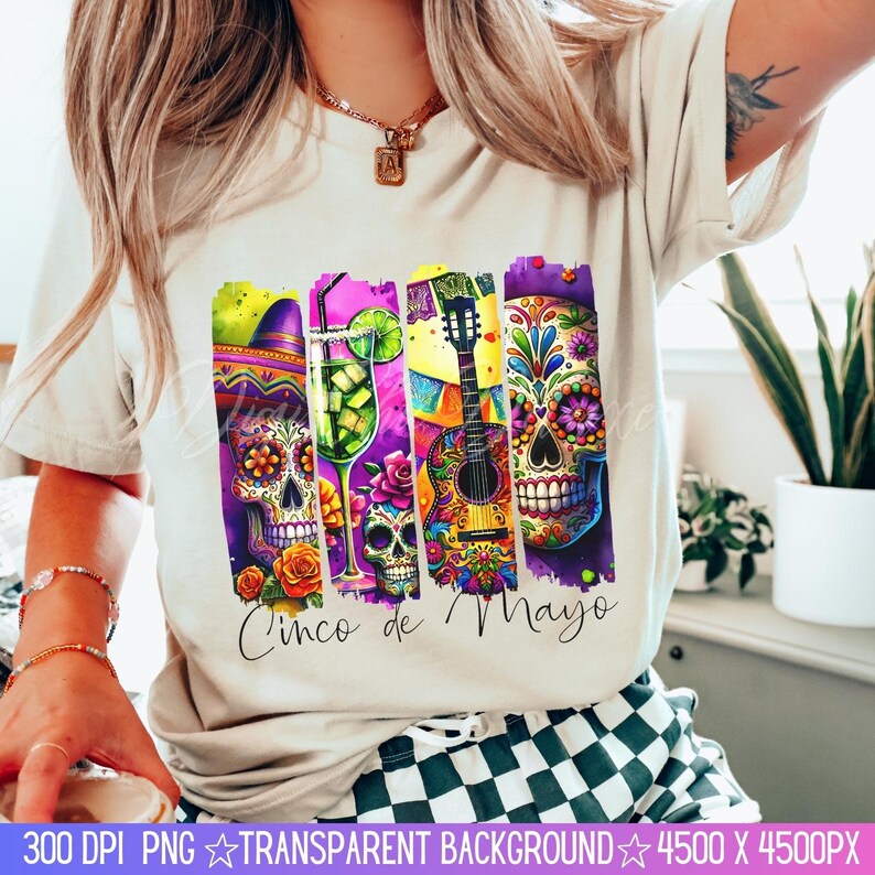 May include: A white t-shirt with a colorful graphic design featuring a guitar, a margarita glass, and sugar skulls. The text "Cinco de Mayo" is printed on the shirt.