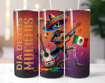 May include: Three stainless steel tumblers with a Día de los Muertos theme. Each tumbler features a skeleton playing a guitar, a sombrero, and a Mexican flag. The background is a vibrant orange with musical notes.