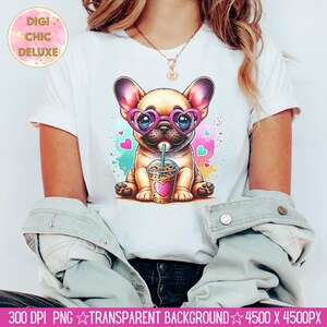 May include: A white t-shirt with a cartoon image of a French bulldog wearing pink heart-shaped sunglasses and drinking a pink and white iced beverage. The background is a colorful watercolor design with pink hearts.