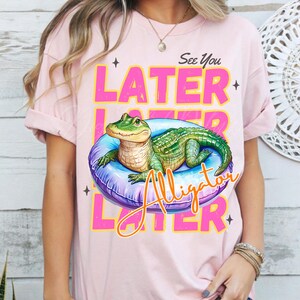 Funny “See You Later Alligator” t-shirt PNG design with cute hand drawn watercolor alligator lounging in a pool float, retro pink and yellow text, summer vacation vibes, beach day shirt, animal humor tee, playful wildlife graphic tee, tropical novelty shirt, kids or adult funny alligator shirt, swamp theme apparel, southern charm gifts, Florida summer shirts, best-selling lake trip shirts, popular quirky animal t-shirt design PNG.