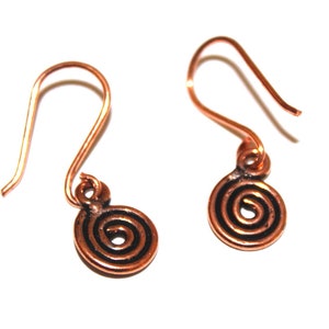 May include: A pair of copper earrings with a spiral design. The earrings are a simple, minimalist style.