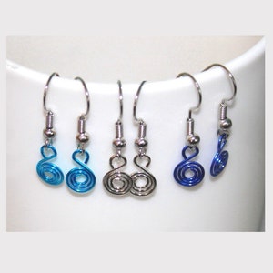 May include: A set of six silver dangle earrings with blue and silver wire spirals. The earrings are displayed on a white surface.
