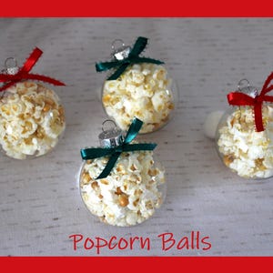 May include: Four clear glass ornaments filled with popcorn, each tied with a ribbon. The ribbons are red, green, and white. The ornaments are labeled "Popcorn Balls".