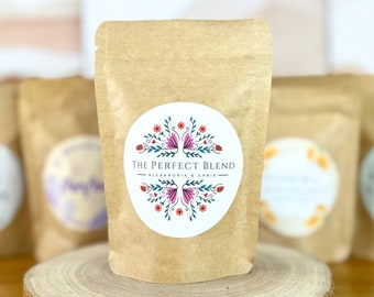 Könnte beinhalten: Ein brauner Papierbeutel mit einem weißen runden Aufkleber, der ein Blumenmuster und den Text "THE PERFECT BLEND - ALEXANDRIA & CHRIS" zeigt.