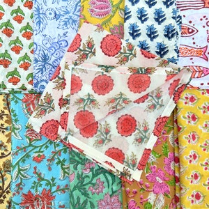 May include: A collection of colourful fabric squares with floral patterns. The fabrics are arranged in a grid pattern and feature a variety of colours, including red, blue, green, yellow, and white.