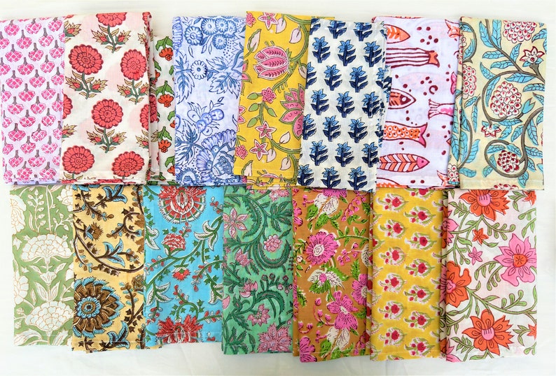 May include: A set of 16 cotton napkins featuring a variety of floral and geometric designs in shades of pink, blue, green, yellow, and brown.