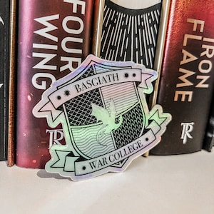 May include: A holographic sticker with a crest featuring a dragon and the text "Basgiath War College" in black.