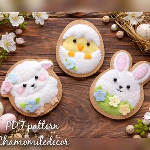 Op de afbeelding: Drie vilten paasdecoraties: een lam, een kuiken dat uit een ei komt en een konijn. Elk heeft een witte body, een bruine rand en pastelkleurige accenten. Het lam en het konijn hebben bloemendetails. De tekst "PDF pattern Chamomiledecor" staat onderaan.