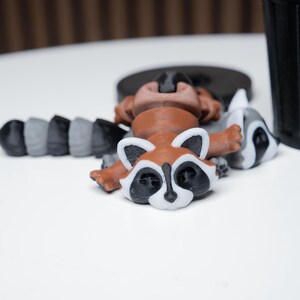 以下が含まれることがあります： 茶色の体と白い顔をしたアライグマの置物、灰色の体と白い顔をしたアライグマの置物、黒と灰色の体をしたアライグマの置物の3体セット。置物はプラスチック製で、リアルな見た目です。