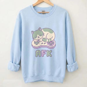 Sleepy Cat on Retro Game Controller Crewneck Sweatshirt | AFK pixel art